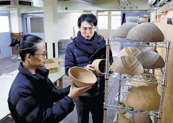 カフェオレベースで出来た製品を確認する村上所長（左）と藤田共同代表（名古屋市西区で）